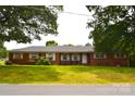 All brick house featuring a well-manicured lawn and mature trees in a quiet neighborhood at 405 Wesley Heights Dr, Albemarle, NC 28001