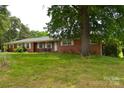 Traditional brick home with a large tree in the front yard and manicured landscaping at 405 Wesley Heights Dr, Albemarle, NC 28001