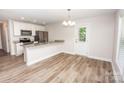 Bright kitchen with white cabinets, stainless steel appliances, granite countertops, and hardwood floors at 506 Broadway Ct, Statesville, NC 28677