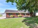 Red brick ranch style house with well manicured lawn and a detached garage at 5105 Hampton Meadows Rd, Monroe, NC 28110