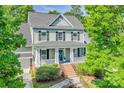 Inviting two-story home with lush green trees and a classic front porch at 5728 Mantario Dr, Charlotte, NC 28269