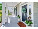 Cozy front porch featuring a decorated front door, plants, and a welcoming atmosphere at 5728 Mantario Dr, Charlotte, NC 28269
