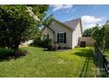 Well-kept yard with green grass, landscaping, and air conditioning unit at 5806 Autumn Trace Ln, Indian Trail, NC 28079