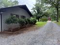 Gravel driveway leading to a well-maintained home with a beautifully landscaped yard at 605 Impala Dr, Albemarle, NC 28001
