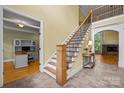Elegant foyer with staircase, decorative railing, and views into an adjacent office and living room at 6565 Robin Hollow Dr, Mint Hill, NC 28227