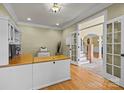 Bright office with hardwood floors, built-in cabinets, and an open doorway to the main foyer at 6565 Robin Hollow Dr, Mint Hill, NC 28227