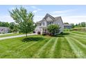 A well-maintained two-story home boasts a lush lawn and convenient two-car garage at 7129 Dove Field Ln, Fort Mill, SC 29707