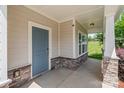 Inviting front porch with stone accents and a stylish blue front door at 7129 Dove Field Ln, Fort Mill, SC 29707