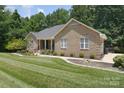 Well-maintained brick home with an attached garage, neat landscaping and freshly cut lawn at 9117 Castle Garden Ln, Charlotte, NC 28215