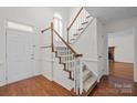 Bright foyer featuring hardwood floors, a carpeted staircase, and natural light from a window above the door at 9121 Four Acre Ct, Charlotte, NC 28210