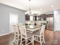 Eat-in kitchen featuring stainless steel appliances, a center island table and hanging light fixture at 9123 Magnolia Lily Ave, Charlotte, NC 28227