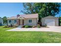 Lovely home with green lawn, detached garage, and welcoming driveway at 1005 Noles Dr, Mount Holly, NC 28120