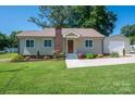 Attractive house featuring a green lawn, complemented by a detached garage at 1005 Noles Dr, Mount Holly, NC 28120