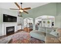 Spacious living room with fireplace, built-ins, ceiling fan, and arched doorways to other rooms at 106 Abbey Cir, Salisbury, NC 28147