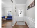 Bright foyer with a glass-paneled front door, decorative wall trim, and hardwood flooring at 117 Autumn Mist Rd, Statesville, NC 28677