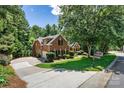 Brick house with a long driveway and a basketball hoop, surrounded by lush greenery and a well-kept lawn at 1399 Verdict Ridge Dr, Denver, NC 28037