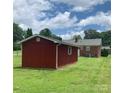 Backyard featuring a red storage shed, brick home exterior, and green lawn at 1901 Taylor Dr, Gastonia, NC 28052