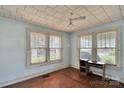 Cozy bedroom with hardwood floors, two large windows, and a ceiling fan at 226 S Morrow Ave, Albemarle, NC 28001