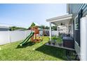 Spacious backyard featuring a play set, a covered patio, and lush green grass at 2526 Snow Creek Ne Rd, Hickory, NC 28601