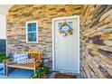 Inviting front porch with stone accents, wreath, and a bench perfect for relaxing at 2526 Snow Creek Ne Rd, Hickory, NC 28601