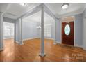 Elegant foyer showcasing hardwood floors, decorative columns, and a stylish front door with transom window at 320 Magnolia St, Davidson, NC 28036