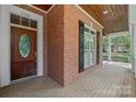 Close-up of a brick porch with a decorative wooden door and brick detail, offering curb appeal and character at 320 Magnolia St, Davidson, NC 28036
