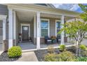 Inviting front porch with a seating area and lovely landscaping at 336 Secretariat Dr, Iron Station, NC 28080