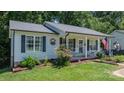 Charming home with a welcoming front porch, lovely landscaping, nice windows, and patriotic decor at 431 Forest Dr, Maiden, NC 28650