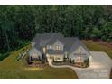 An aerial view of a stately home surrounded by lush trees and landscaping at 440 Bridlewood Dr, Gold Hill, NC 28071