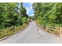 Long gravel driveway leads through lush woods to a beautiful estate at 440 Bridlewood Dr, Gold Hill, NC 28071