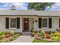 Charming one-story home featuring a white brick exterior, black shutters, and landscaped garden at 5501 Murrayhill Rd, Charlotte, NC 28210