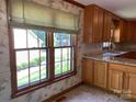 Wood cabinets, granite countertop and large windows with nature views make this kitchen appealing at 6632 Summer Darby Ln, Charlotte, NC 28270