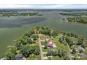 Aerial view of a waterfront property with mature trees and a sprawling lake in the background at 7478 Pine Ridge Dr, Denver, NC 28037