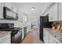 Well-lit kitchen featuring stainless steel appliances, granite countertops, white subway tile, and wood-look flooring at 8012 Red Lantern Rd, Indian Trail, NC 28079