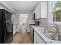 Bright kitchen with stainless steel appliances, granite countertops, white cabinets, subway tile backsplash, and wood floors at 8012 Red Lantern Rd, Indian Trail, NC 28079