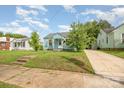 Quaint light blue home with a walkway, grassy lawn, and mature trees at 1019 Richard St, Salisbury, NC 28144