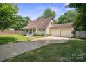 Charming home featuring a well-manicured lawn and a convenient two-car garage at 10206 Washam Potts Rd, Cornelius, NC 28031
