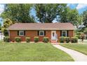 Inviting brick home with a well-manicured lawn and mature shrubbery, creating great curb appeal at 1219 Flowe Dr, Matthews, NC 28104