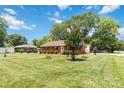Beautiful well-maintained lawn and landscaping surround a charming brick home on a sunny day at 1219 Flowe Dr, Matthews, NC 28104