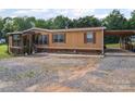 Side view of single-Gathering home featuring a spacious driveway and a covered parking area at 130 Benton Rd, Kings Mountain, NC 28086