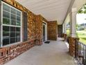 Inviting covered front porch features brick accents and ample space for outdoor seating and relaxation at 17012 Alydar Commons Ln, Charlotte, NC 28278