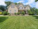 Charming two-story home with manicured lawn and stone accents, captured on a bright day at 1808 Mill Chase Ln, Waxhaw, NC 28173