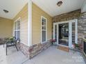 Inviting front porch with stone accents, chairs, and a 'Welcome' mat leads to a charming home's entrance at 1808 Mill Chase Ln, Waxhaw, NC 28173