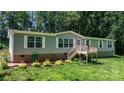 Charming home features a quaint front deck, well-maintained lawn, and mature trees for privacy at 200 Vista Pointe Dr, Stony Point, NC 28678
