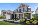 Beautiful two-story home boasts a landscaped yard, covered front porch, and attached two-car garage at 235 Boxelder Rd, Clover, SC 29710