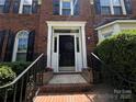 Welcoming front entrance with a black door, white trim, and decorative flower planters at 2609 Lamp Post Ln, Kannapolis, NC 28081