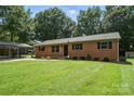 Brick house with a well-kept lawn, sidewalk, and carport on a sunny day at 2705 Lowell Bethesda Rd, Gastonia, NC 28056