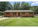 Traditional brick ranch-style home featuring a lush front yard, manicured landscaping, and a welcoming entrance at 2705 Lowell Bethesda Rd, Gastonia, NC 28056