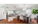 Inviting living and dining area with hardwood floors, neutral paint, modern chandelier, and plenty of natural light at 3109 Buckleigh Dr, Charlotte, NC 28215