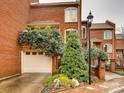 Elegant brick townhome with attached garage adorned with verdant foliage and manicured landscaping at 311 Settlers Ln, Charlotte, NC 28202